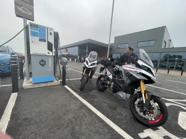 two electric motorcycles being recharged