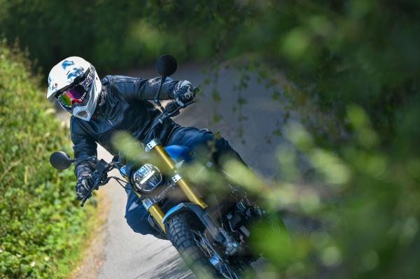 A motorcycle being ridden down a country lane