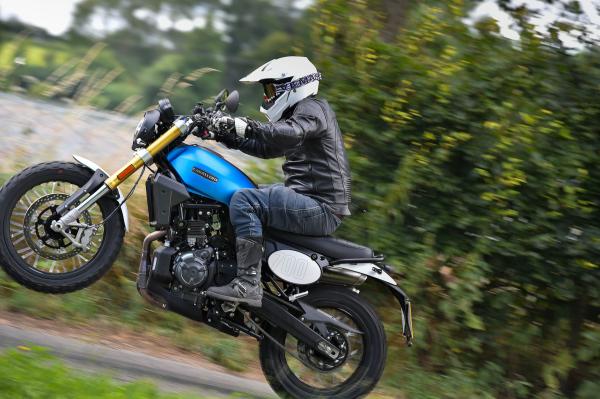 A motorcyclists pulling a wheelie on a private road