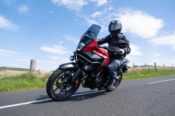 A motorcycle riding around a corner on a country road