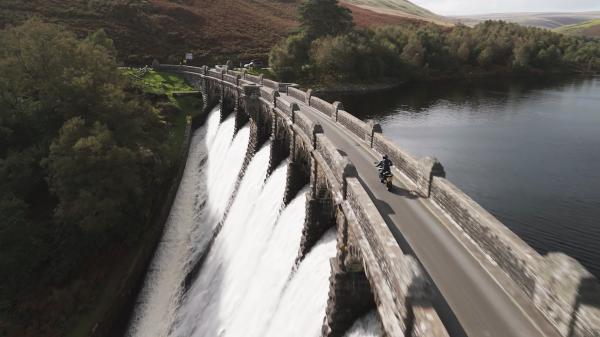 A motorcycle riding over a dam in Wales